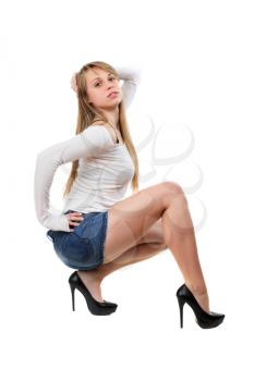 Young woman posing in blue jeans shorts, white blouse and black shoes. Isolated