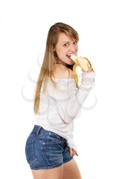 Joyful young woman with long blond hair eating banana. Isolated on white