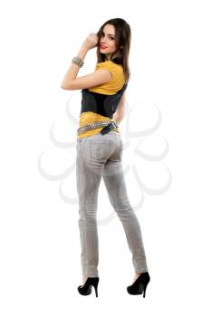 Young leggy brunette posing in grey jeans and black shoes. Isolated on white