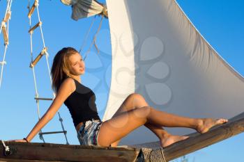 Cute teen girl sitting at stern of the ship