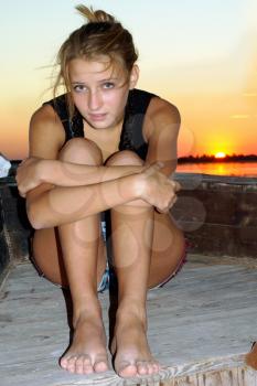Upset teen girl sitting at stern of the ship