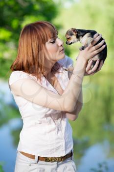 Young red-haired woman holding funny little dog