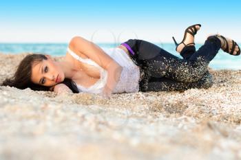 Alluring young woman lying on the sand