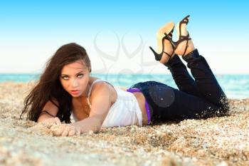 Provocative young woman lying on the beach