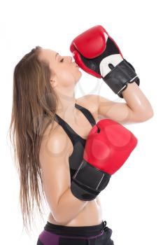 Portrait of young woman kissing boxing gloves. Isolated on white