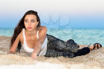Pretty young woman posing near the sea