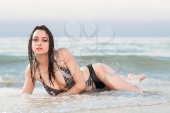 Beautiful young brunette lying in the sea