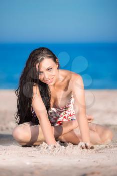 Pretty young brunette posing on the beach
