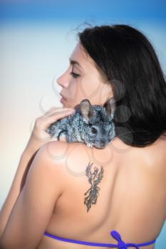 Portrait of young brunette posing with chinchilla