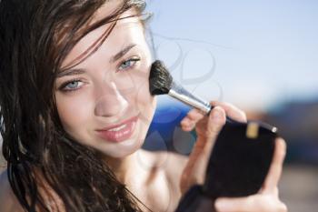 Portrait of pretty brunette posing with a brush for makeup