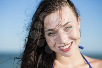 Portrait of young smiling woman posing at the seaside