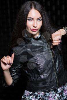 Pretty playful brunette posing in flowered dress and leather black jacket. Isolated