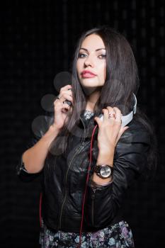 Pretty brunette posing with headphones. Isolated on black