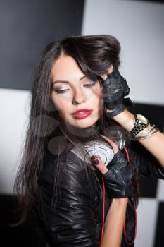 Portrait of sexy brunette posing with headphones in the studio