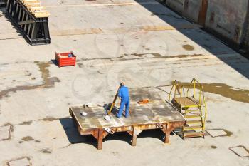 Engineer performs measurements in dry dock shipyard