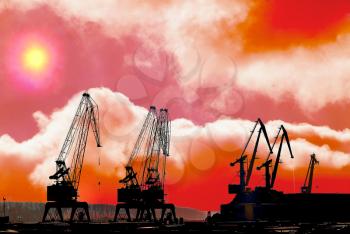 Silhouettes of cranes in the shipyard. at sunset
