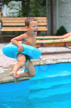 Joyful boy are jumping to the swimming pool