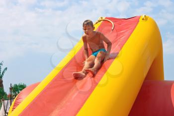 Enthusiastic kid on slide in the waterpark 