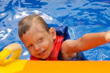 Enthusiastic kid in vest at the pool water park 
