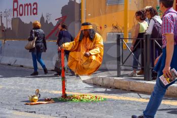 ROME, ITALY - MAY 04, 2014: Street performer in clothing monk demonstrates  trick of levitation in Rome, Italy