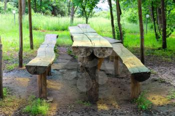 Table and benches made of logs are in the park 