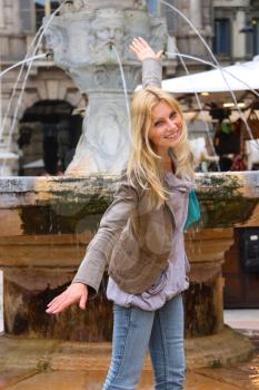 Attractive girl near a fountain of Madonna on Piazza delle Erbe in Verona, Italy