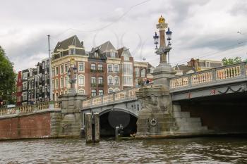 Amsterdam, Netherlands - June 20, 2015: People on the beautiful old bridge in the historic part of Amsterdam