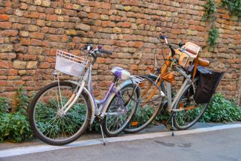 Two bicycles near brick wall in the center of Rimini, Italy