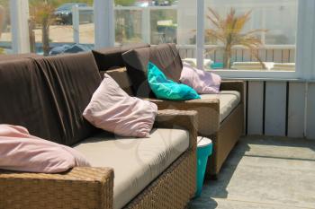 Soft sofas with colorfull pillows in the beach cafe terrace. Zandvoort, the Netherlands