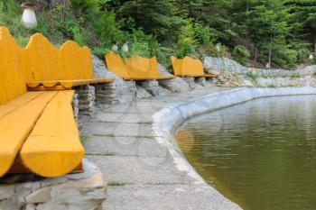 Original wooden benches on shore of lake in Ukrainian Carpathians