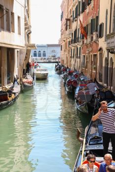 Venice, Italy - August 13, 2016: Tourists in gondola on canal of Venice
