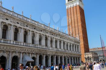Venice, Italy - August 13, 2016: Tourists walking on famous St. Mark's Square near St. Mark's Campanile (Bell Tower)