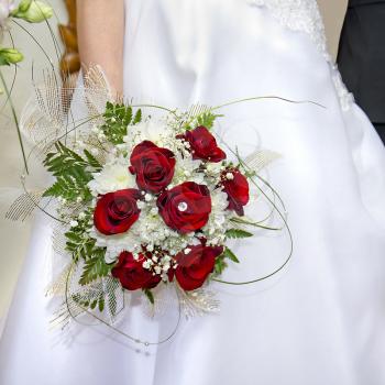 bouquet of red roses in her hand up on the bride