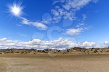Sand hills and blue sky with clouds