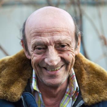 Portrait of a smiling elderly man outdoors closeup