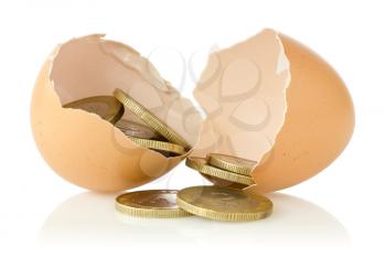 Broken  eggs with coins on white background 