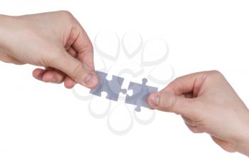 Two hands connecting puzzle pieces. Isolated on white background