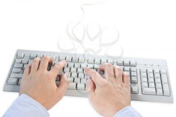 hands typing on a grey computer keyboard 