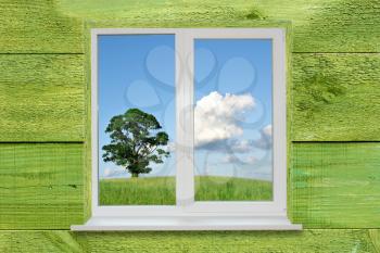 Landscape in the window on green wooden wall