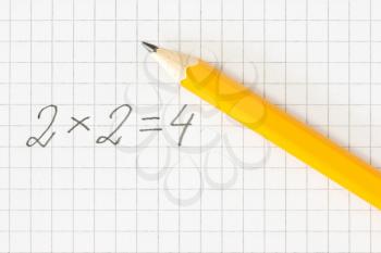Simple math formula and pencil on squared paper