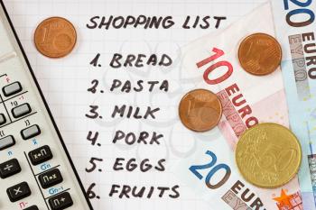 Calculator, Euro currency and handwritten shopping list
