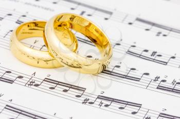 Golden wedding rings on the old sheet music