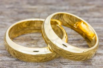 Pair of golden wedding rings on a wooden floor