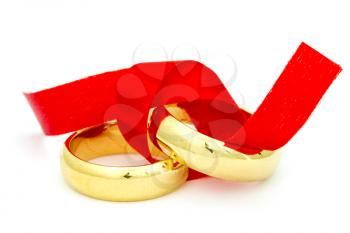 Two golden rings tied with red bow. Isolated on white background