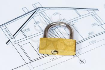 Concept of housing. Architectural house drawings with yellow padlock