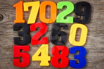 Colorful plastic numbers on the wooden background