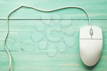 Computer mouse on the wooden background with copy-space. Image tones in pastel colors