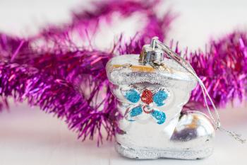 Old shoe shaped christmas bauble with purple tinsel