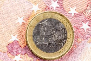 Detail of one euro coin on red ten euro banknote background