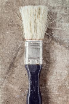 Old paintbrush on a dirty canvas surface, close up